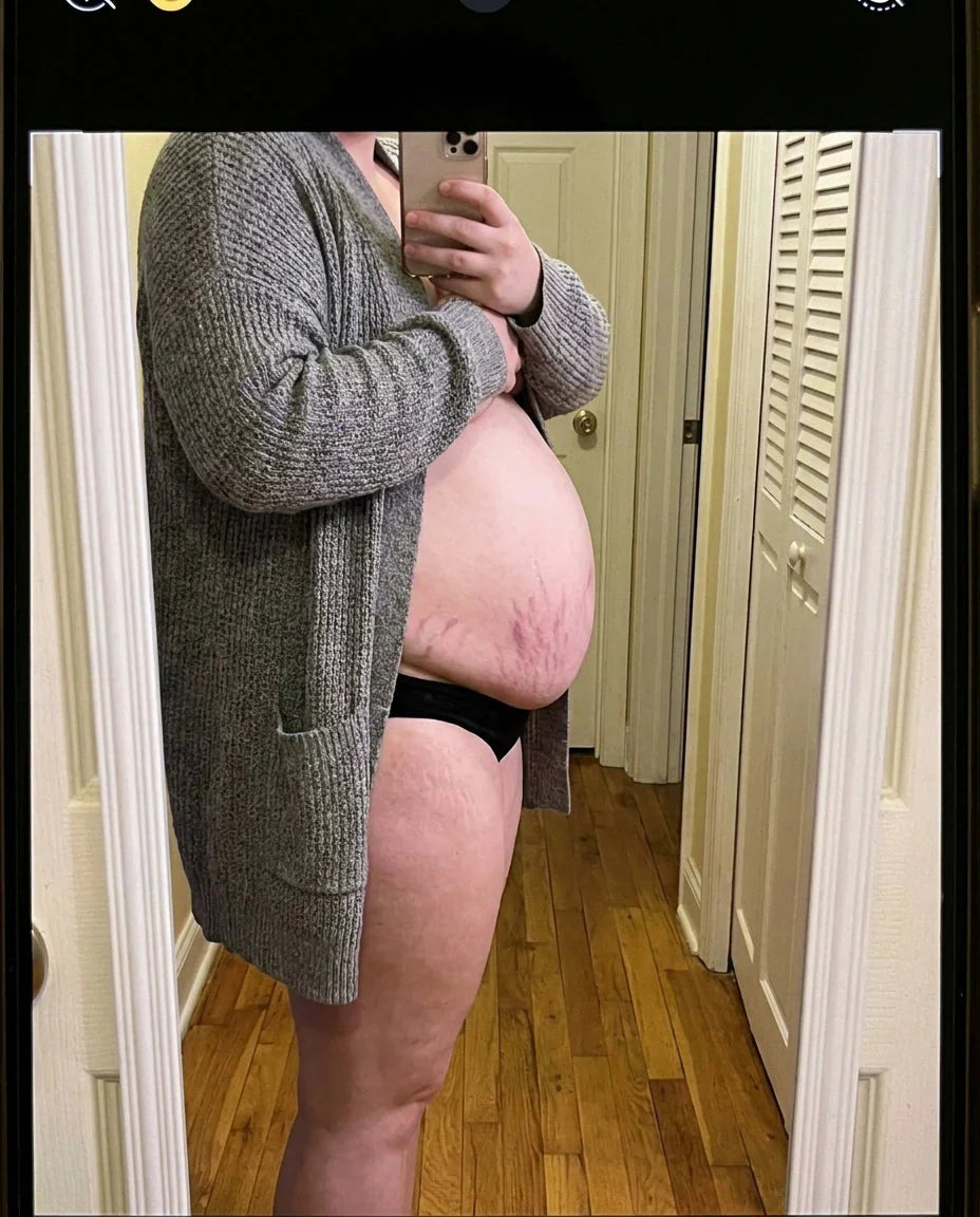 Profil d'un ventre post-partum, photo miroir à la maison